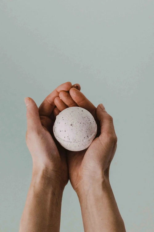rounded bath bomb held in hands