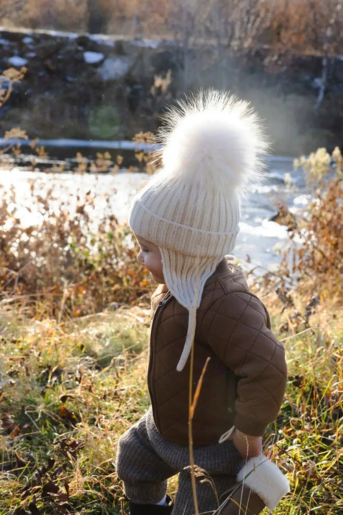 child wearing hat with big pompoms 