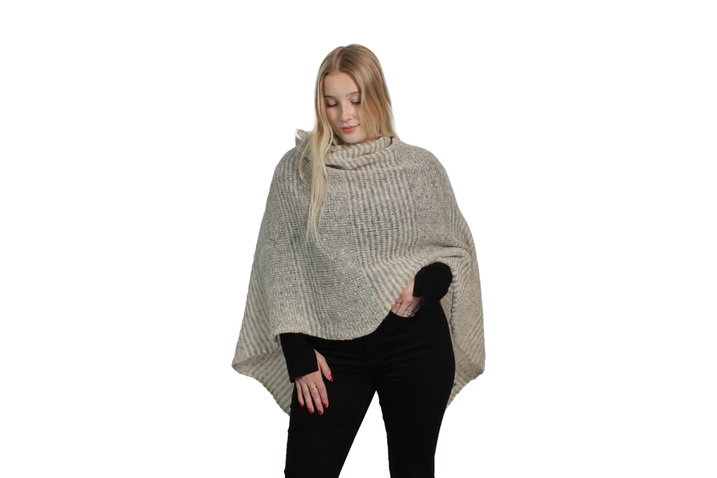 Woman wearing a beige knitted poncho on a white background